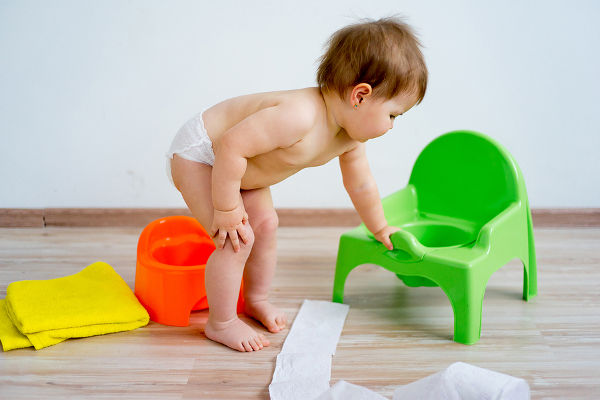 Cute smiling baby sitting on the potty