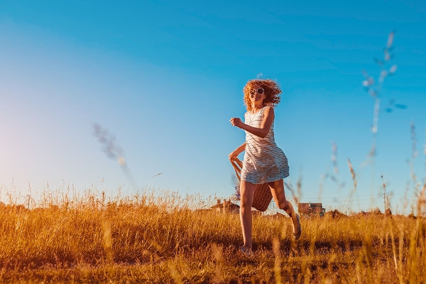 fashionable-woman-running-through-field