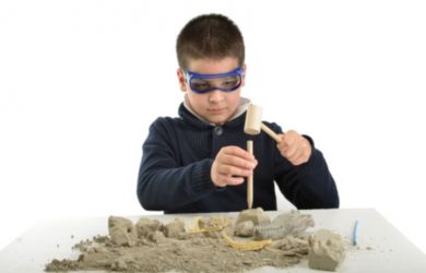 Child using tools at an archeology dig site