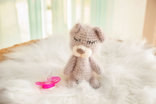 Cute baby toy and pacifier on fluffy plaid