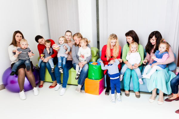 Group Of Mothers With Their Kids Gathered To Talk. Friends Meeti