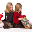 Beautiful twin sisters opening Christmas gifts