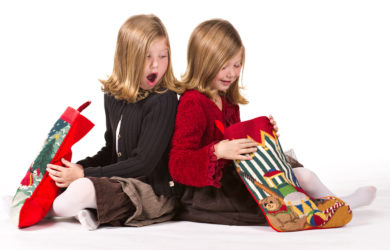 Beautiful twin sisters opening Christmas gifts