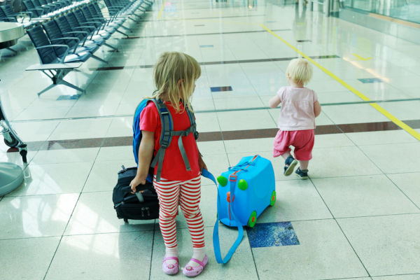 kids with suitcase travel in the airport, family travel