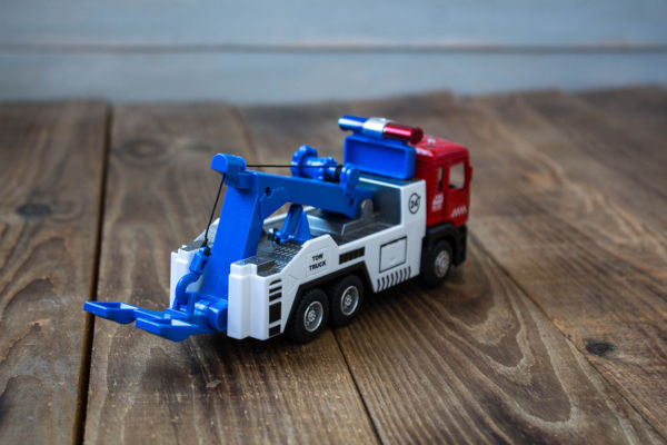 a tow truck childrens toys on wooden background