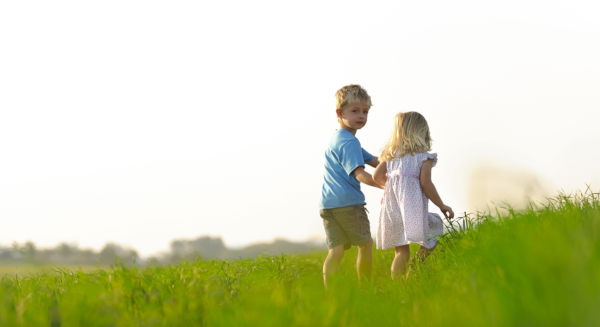 Brother and sister playing together in a field