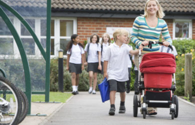 Woman Leaving School With Child And Push Chair