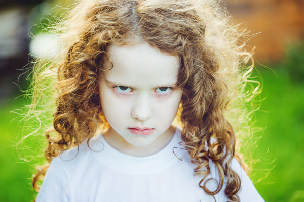 Emotional child with angry expression on face.