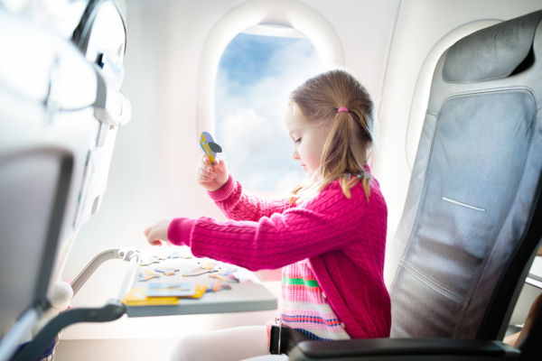 Young girl sat in aeroplane