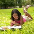 Girl Reading A Book In The Park