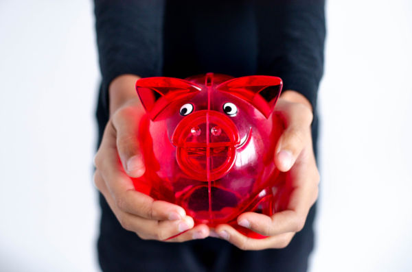 Red pig money box held in a woman's hands