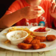 Boy eating chicken nuggets and chips