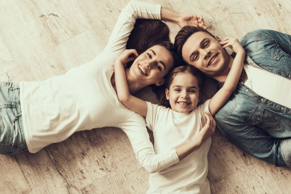 Happy Family Lying Of Floor Together At Home. 