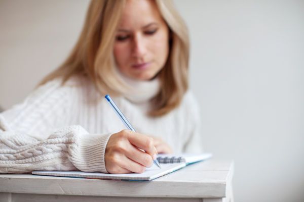Woman writing pen in notebook. Female writing letter