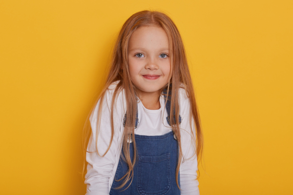 Smiling little girl on a yellow background