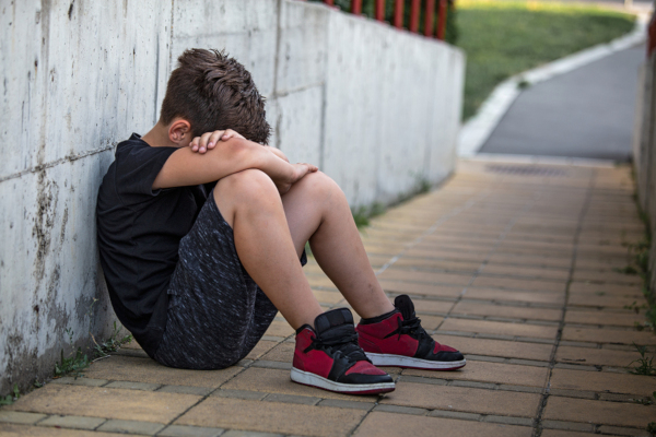 Little Boy Sad Sitting Alone At School Hides His Face. Isolation