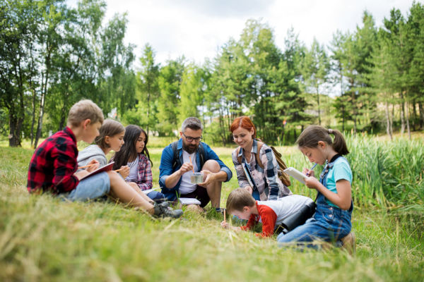 Group Of School Children With Teacher On Field Trip In Nature