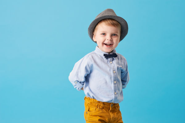 Happy little boy wearing a bowtie and hat