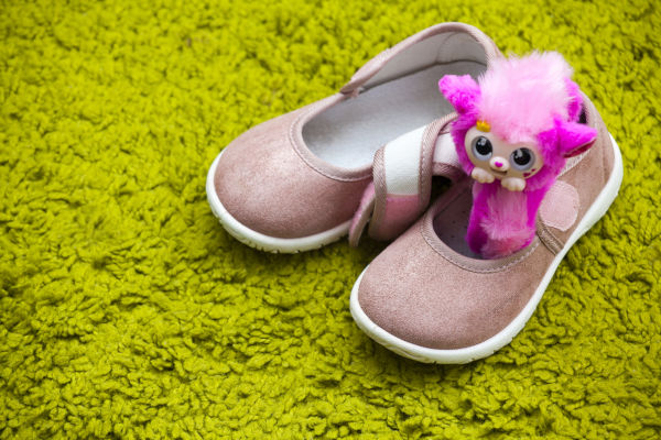 Little girl's shoes with a pink toy inside