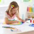 Girl painting a rainbow indoors