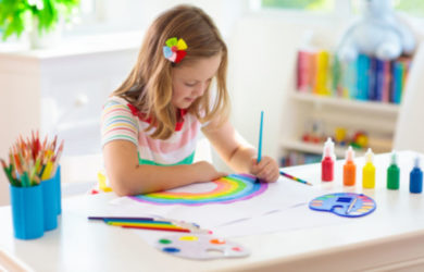Girl painting a rainbow indoors