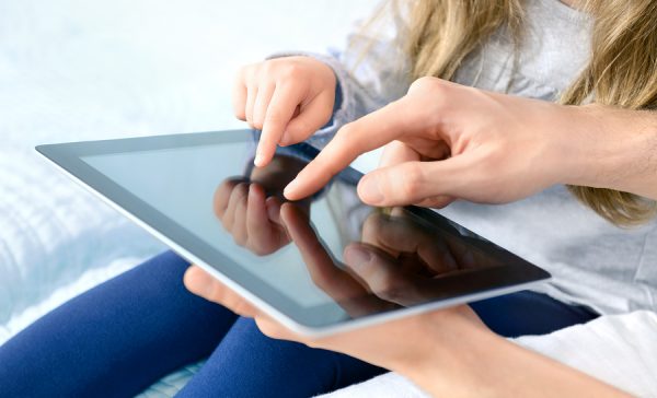 Father and child playing on a tablet