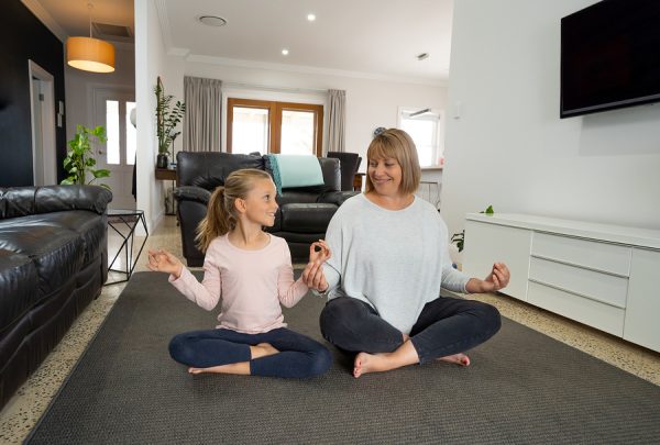 COVID-19 Shutdown. Mother and daughter in quarantine doing yoga indoors.