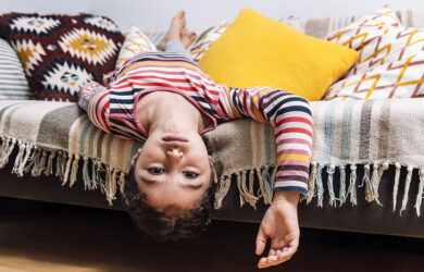 Bored girl hanging upside down over her bed