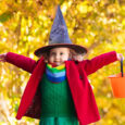 Kids trick or treat on Halloween night. Little girl with pumpkin face candy bucket. Child trick or treating.