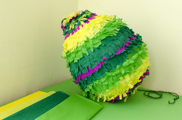 colored paper pinata on white wooden table